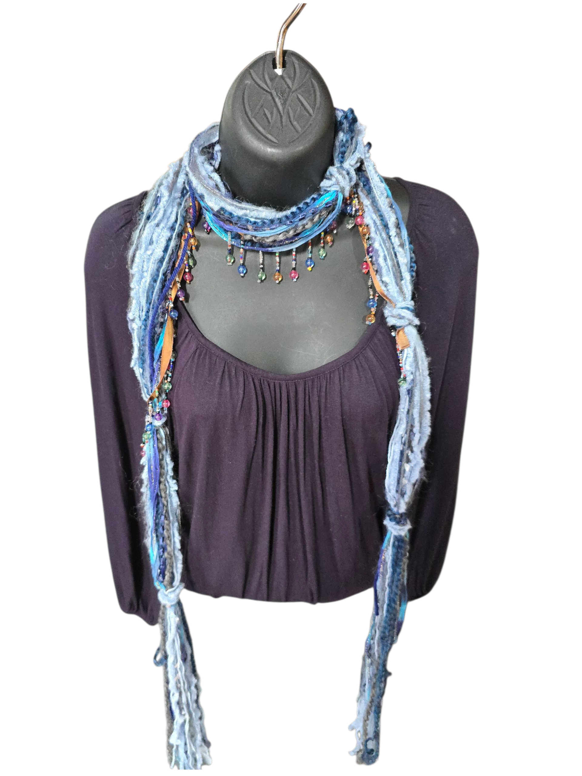 Blue scarf with tassels on a mannequin against a white background